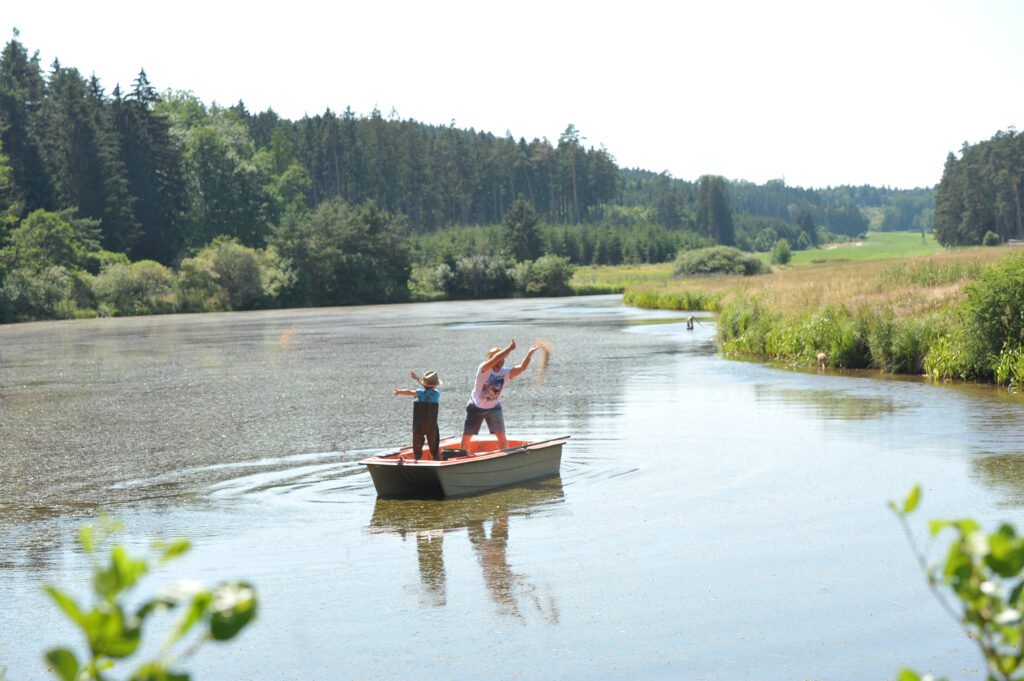 Zwei Generationen der Familie Huber am Fischweiher bei der Arbeit